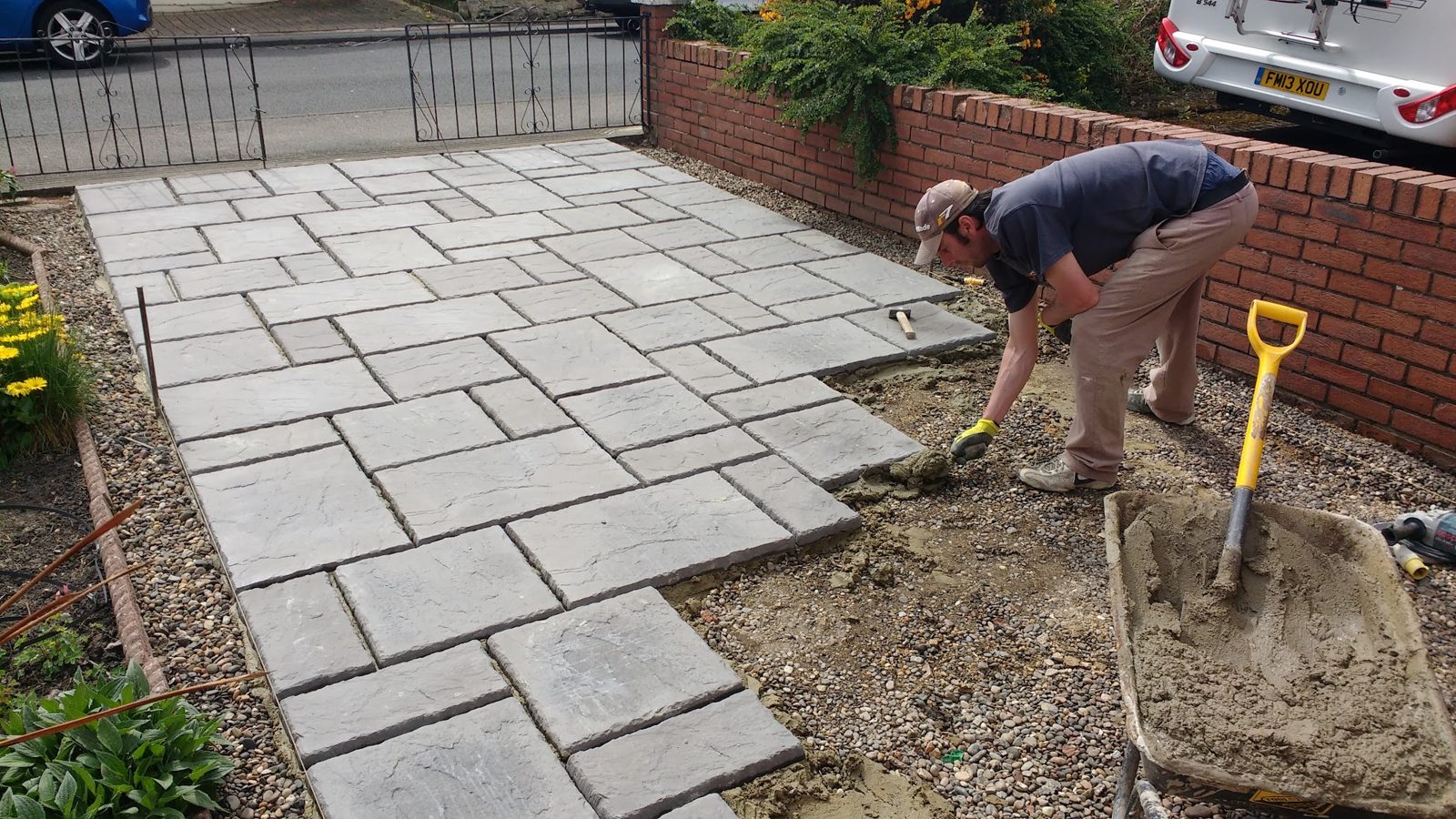 Justin laying grey paving flags for a front path