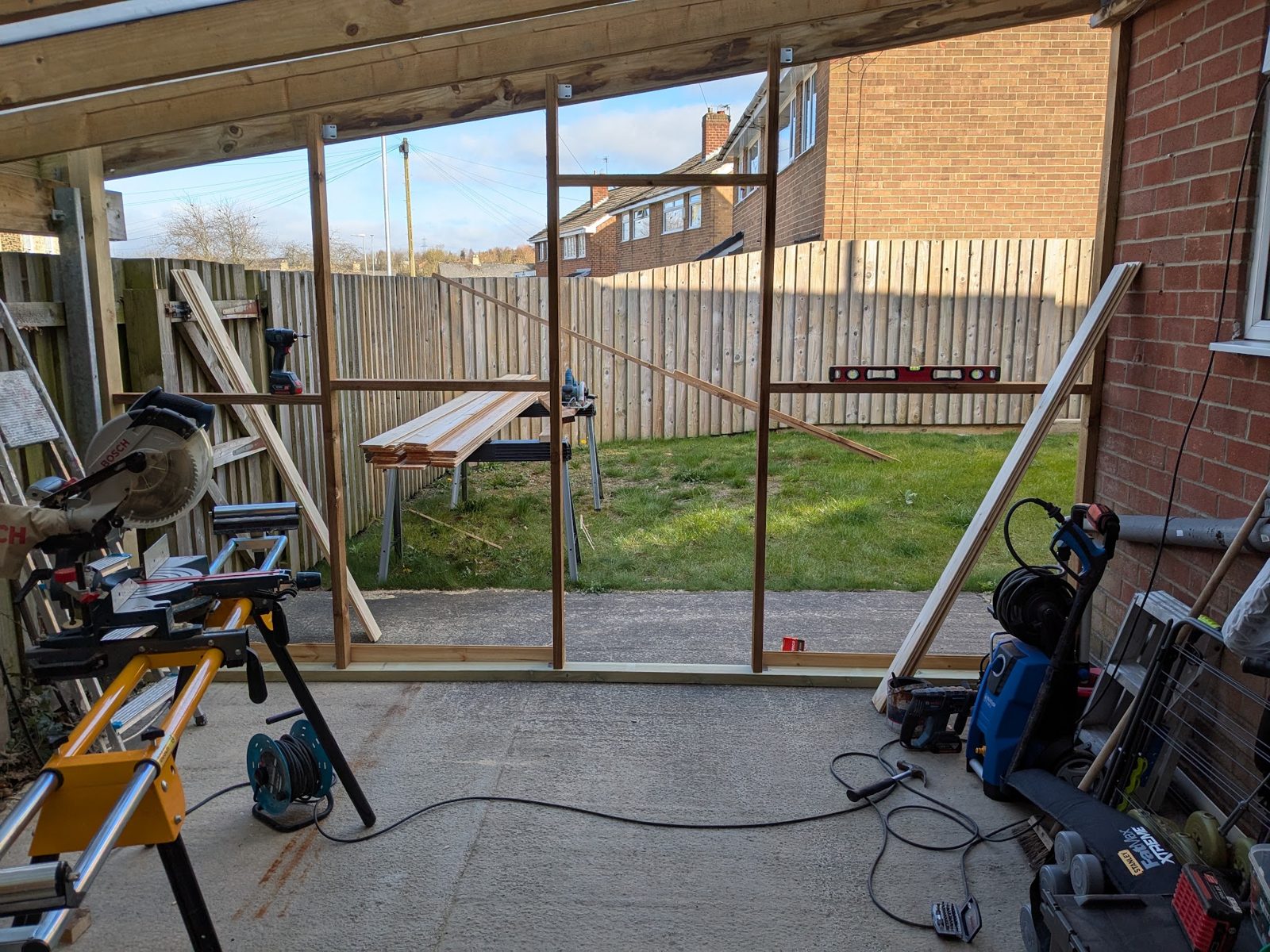 A timber canopy frame going up at the back of a house
